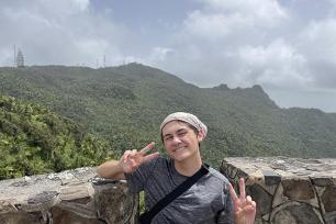 Caden Vitti poses in front of mountains at El Yunque