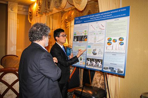 Guijie Sang discusses his research with Semih Eser at the 2018 Research Showcase