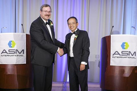 Zi-Kui Liu shakes hands with David Furrer at a ceremony in fall 2019