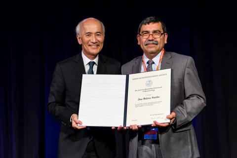 Jose Fuentes, right, accepts an award from the American Meteorological Society
