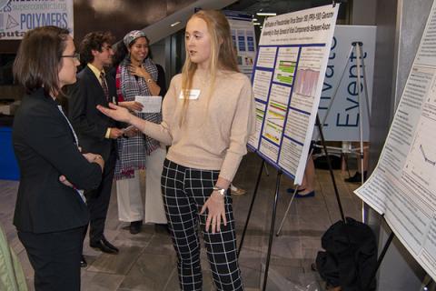Allison Beese, left, discusses research with student Anna Wickenheisser during the WISER/MURE/FURP symposium