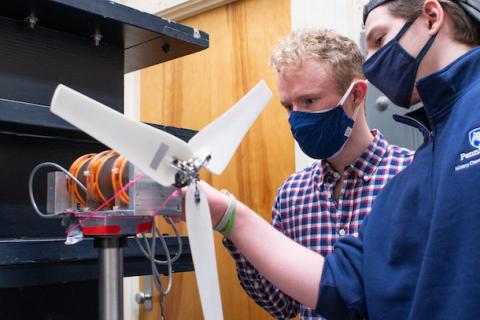 Josh Forrest (left),  and Eric Sarbacker, junior, assemble a test wind turbine to prepare for the upcoming wind competition
