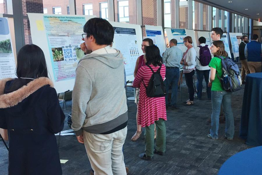 Faculty, staff, postdocs and students discuss microbiome research during a networking event.