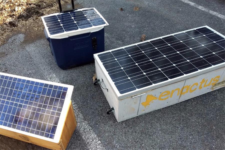 A “Solar Saver” box built by Penn State students, center, is displayed with other solar boxes bound for Puerto Rico.