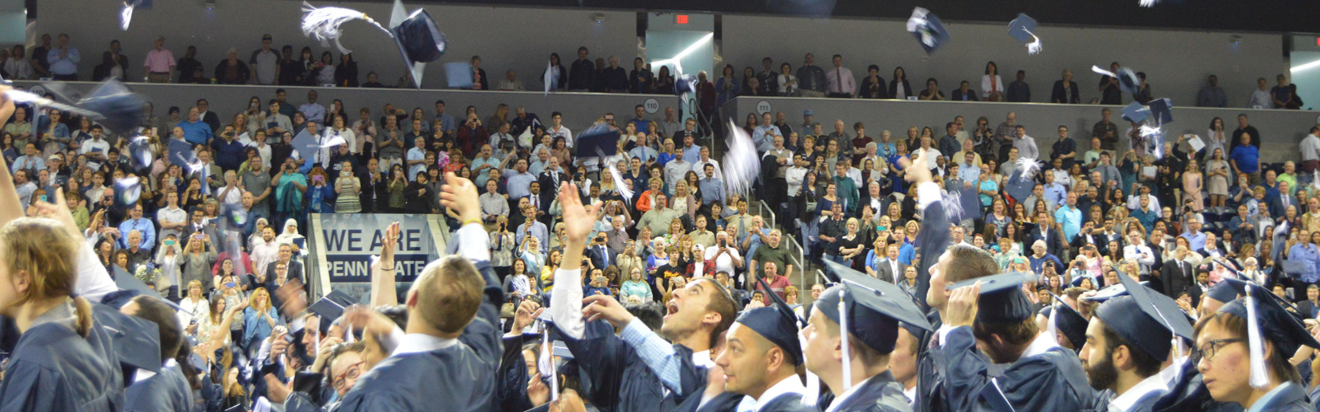 Students tossing graduation caps at 2017 commencement ceremony