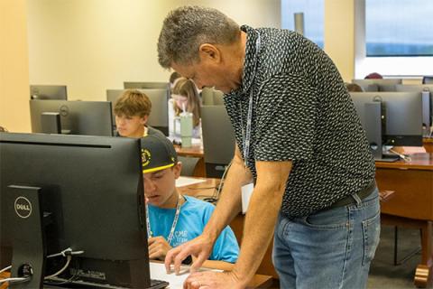 William Syrett helps a weather camp student with an exercise