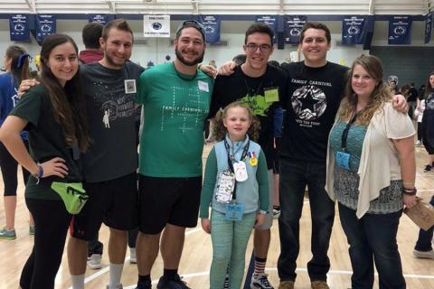 Friends and EMS THON members pose with one of the Four Diamonds families at the THON Family Carnival held at the IM Building.