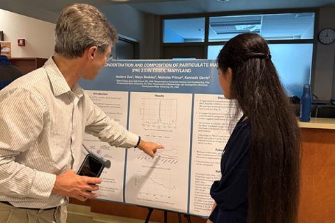 Kenneth Davis, left, professor of atmospheric and climate science in the College of Earth and Mineral Sciences, discusses a potential link for future research with high school student Isadora Zuo at Penn State's EnvironMentors Research Symposium on April 26