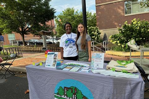 Jasmine Fields, left, engages with the public on local sustainability efforts during the Living in One Neighborhood (LION) Bash in 2024. Fields, a 2018 Penn State graduate in geosciences, is the sustainability program officer for the Borough of State College
