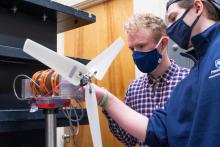 Josh Forrest (left),  and Eric Sarbacker, junior, assemble a test wind turbine to prepare for the upcoming wind competition